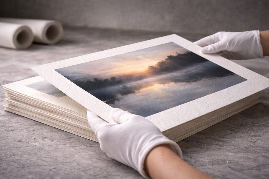 Giclée print being handled with white cotton gloves